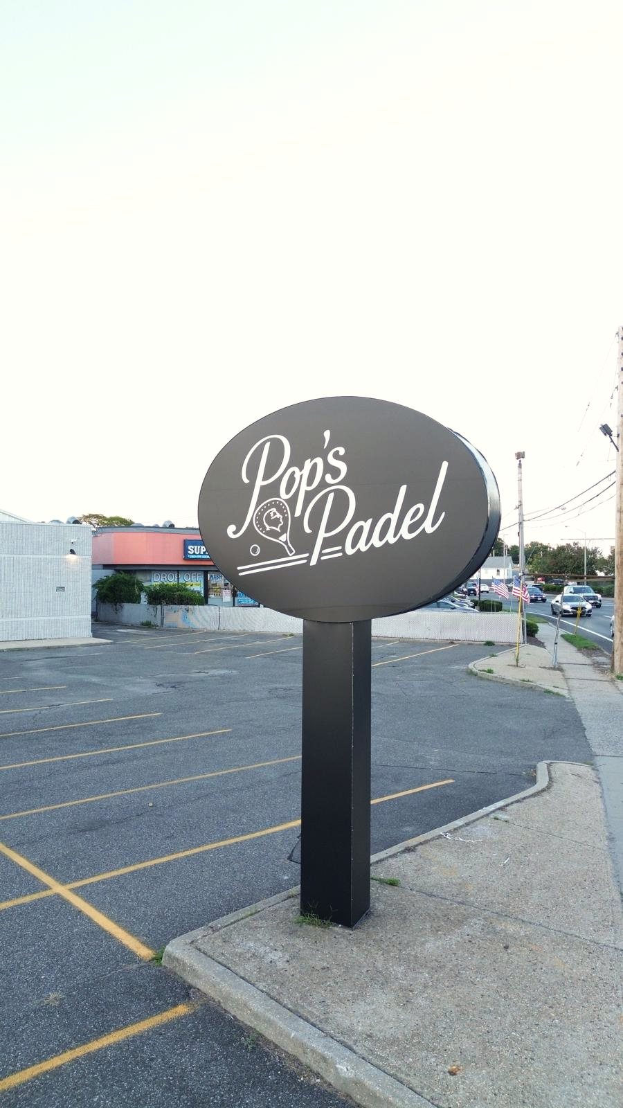 El cartel ovalado de Pop's Padel a la entrada del club