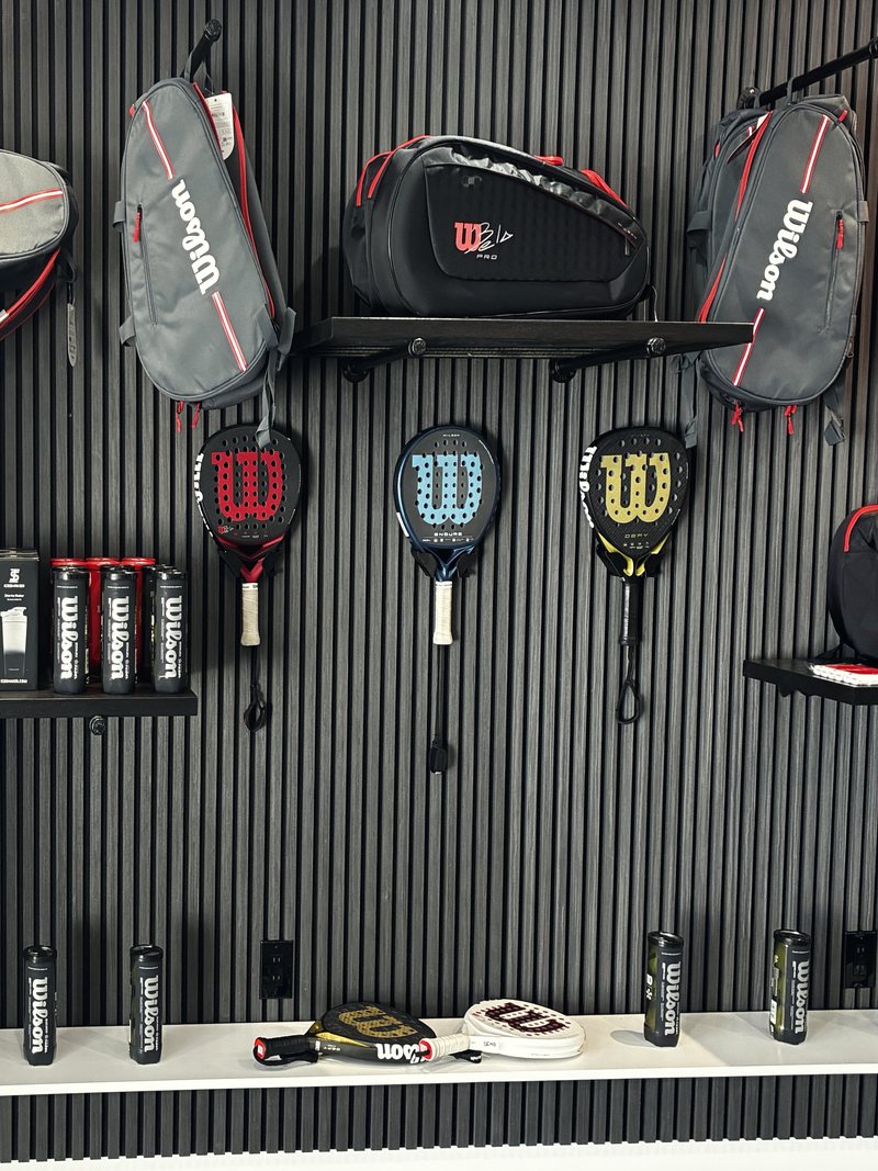 Pared de la tienda con palas, paleteros y bolas Wilson